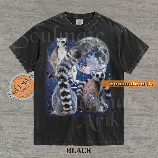 Collage of ring-tailed lemurs in various poses in front of a glowing full moon and a starry nebula on a washed black shirt.