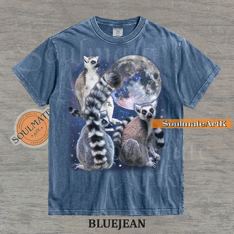 Collage of ring-tailed lemurs in various poses in front of a glowing full moon and a starry nebula on a washed bluejean shirt.