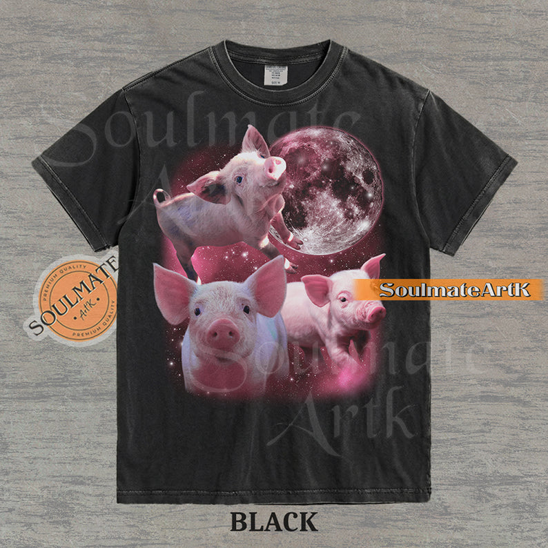 Collage of three pink piglets in front of a glowing pink moon and a starry nebula on a washed black shirt.
