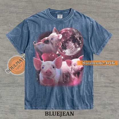 Collage of three pink piglets in front of a glowing pink moon and a starry nebula on a washed bluejean shirt.