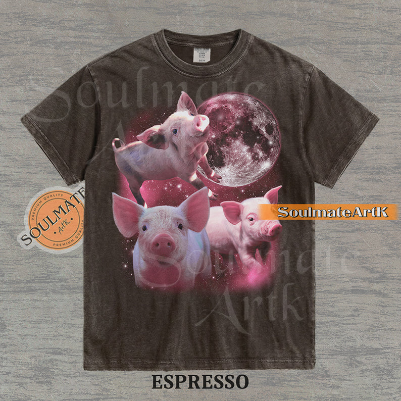 Collage of three pink piglets in front of a glowing pink moon and a starry nebula on a washed espresso shirt.