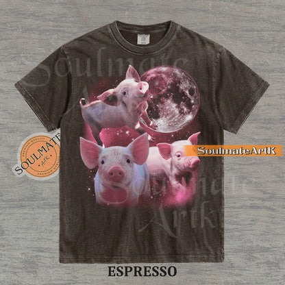 Collage of three pink piglets in front of a glowing pink moon and a starry nebula on a washed espresso shirt.