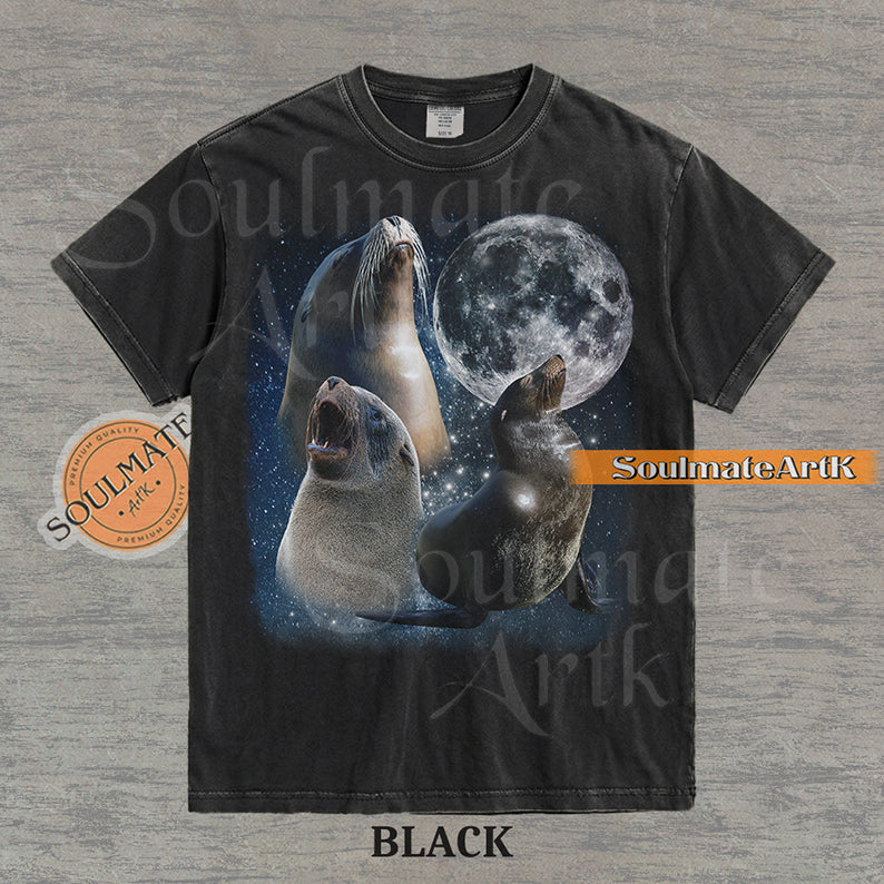 Collage of three sea lions in front of a glowing full moon and a starry night sky on a washed black shirt.