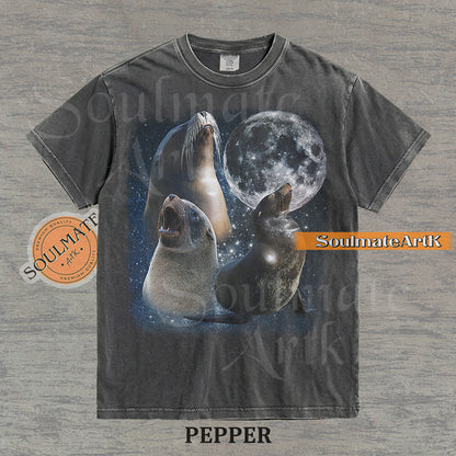Collage of three sea lions in front of a glowing full moon and a starry night sky on a washed pepper shirt.
