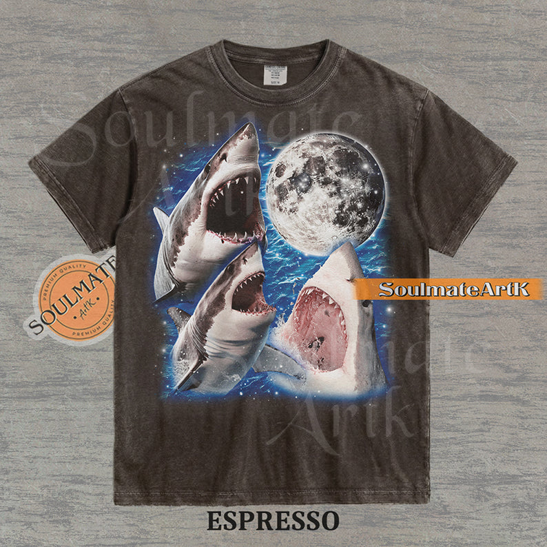 Collage of three great white sharks breaching water in front of a glowing full moon and a starry blue nebula on a washed espresso shirt.