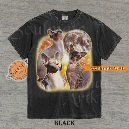 Collage of three Sphynx cats in front of a glowing moon and a golden starry nebula on a washed black shirt.