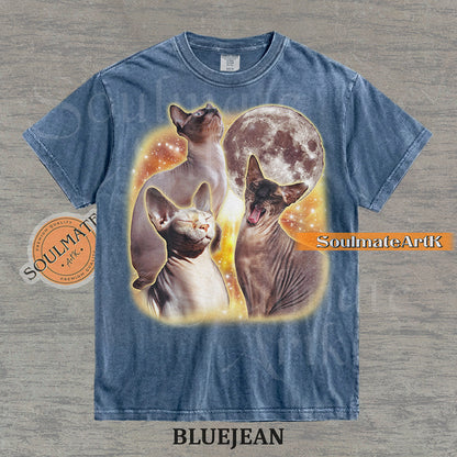 Collage of three Sphynx cats in front of a glowing moon and a golden starry nebula on a washed bluejean shirt.