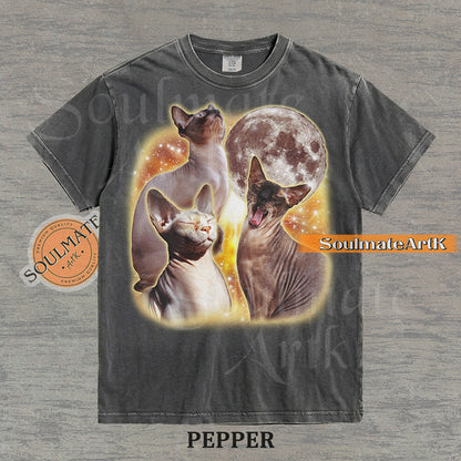 Collage of three Sphynx cats in front of a glowing moon and a golden starry nebula on a washed pepper shirt.