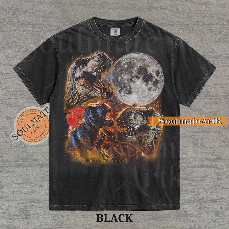 Graphic collage of three T-Rexes next to a large full moon in a starry, colorful space setting on a washed black t-shirt.