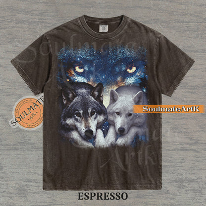 Vintage-style celestial graphic of a timber wolf and arctic wolf resting beneath large glowing wolf eyes in a starry sky on a espresso t-shirt.