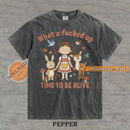 Illustration of a startled girl with a bunny and deer in a forest with the text "What a fucked up TIME TO BE ALIVE" on a washed pepper t-shirt.