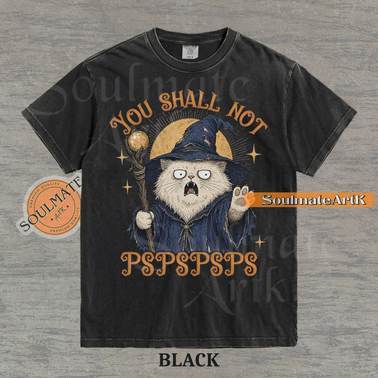 Vintage-style illustration of a white cat dressed as a wizard with a staff and hat, featuring the text You Shall Not PSPSPSPS on a washed Comfort Colors t-shirt.