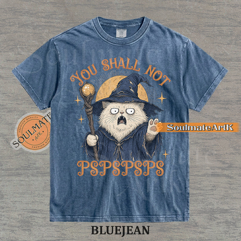 Vintage-style illustration of a white cat dressed as a wizard with a staff and hat, featuring the text You Shall Not PSPSPSPS on a washed Bluejean Comfort Colors t-shirt.