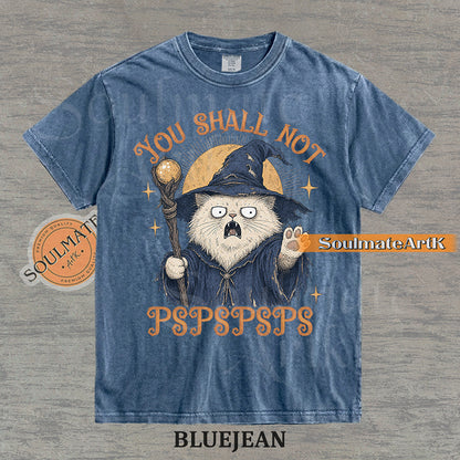 Vintage-style illustration of a white cat dressed as a wizard with a staff and hat, featuring the text You Shall Not PSPSPSPS on a washed Bluejean Comfort Colors t-shirt.