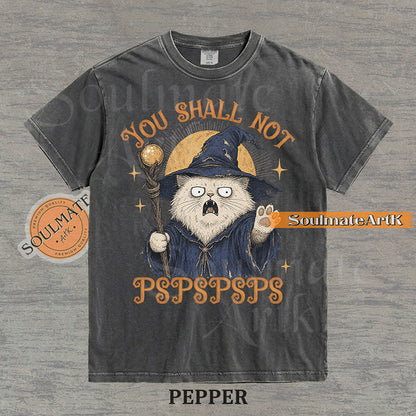 Vintage-style illustration of a white cat dressed as a wizard with a staff and hat, featuring the text You Shall Not PSPSPSPS on a washed Pepper Comfort Colors t-shirt.